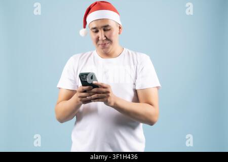 Giovane uomo allegro che invia messaggi sul suo smartphone cellulare Foto Stock