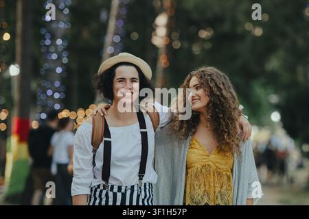 Due giovani donne amiche che camminano al festival estivo. Foto Stock