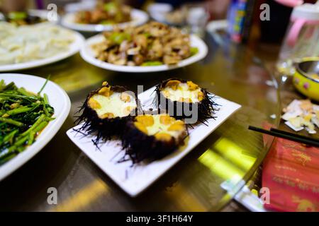 Una varietà di piatti asiatici esposti su un tavolo, inclusi frutti di mare e verdure. Foto Stock