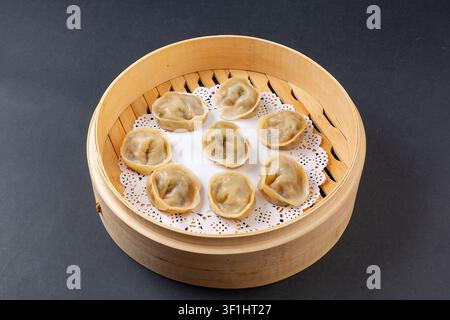Vista dall'alto dei gnocchi kimchi coreani al vapore Mandu in un tradizionale cestino di bambù a vapore Foto Stock