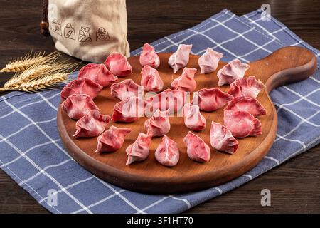 Dumplings di verdure colorati crudi e freschi su piatti, Jiaozi cinesi congelati Foto Stock