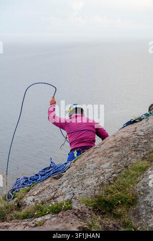 Arrampicatore che avvolge una corda sul bordo della scogliera a Palisade Head sopra il Lago Superiore in Minnesota Foto Stock