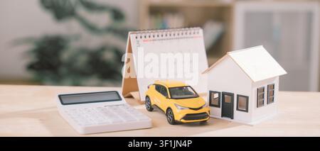 Pianificazione finanziaria per investimenti immobiliari, prestito auto, calcolatore delle caratteristiche dell'assicurazione casa posizionato accanto al modello di casa, calendario aiuta a tracciare la ricchezza uomo Foto Stock