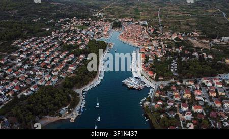 Vista aerea di Stari Grad sull'isola di Hvar, Croazia, che mostra la marina, le case del centro storico e le aree residenziali alla sera Foto Stock