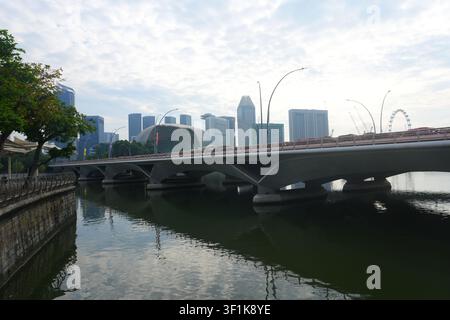 Ponte dell'Esplanade sul tranquillo fiume di Singapore Cielo morbido e nuvoloso dello skyline dei grattacieli del centro Foto Stock