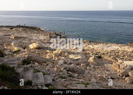 Vista ad angolo alto di una costa rocciosa in calcare lungo il calmo mare blu del Mediterraneo a Malta. Foto Stock