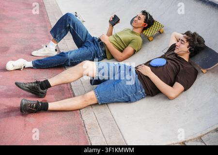 Due giovani amici che ascoltano musica con il lettore di cassette e cd - nuovo stile di vita delle persone di tendenza con dispositivi analogici vintage Foto Stock