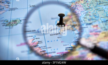 Lente d'ingrandimento su una mappa cartacea che segna la destinazione Stavanger in Norvegia Foto Stock