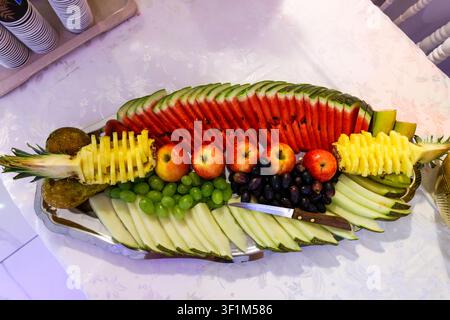 Vassoio decorativo di frutta fresca con anguria, ananas, uva, mele e melone a un evento organizzato Foto Stock