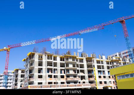 Bucarest, Romania - 20.08.2026: Costruzione di nuovi edifici residenziali con gru per grattacieli Foto Stock