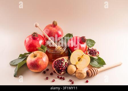 Una bellissima composizione di simboli tradizionali di Rosh Hashanah tra cui mele, melagrane, miele e noci, che rappresentano dolcezza, abbondanza, un Foto Stock