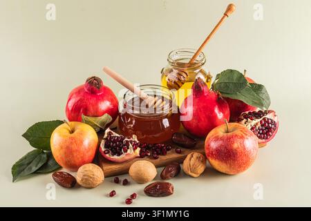 Una vivace esposizione di simboli tradizionali di Rosh Hashanah tra cui mele, miele, melagrane e noci, che simboleggiano speranza e dolcezza per il N ebraico Foto Stock