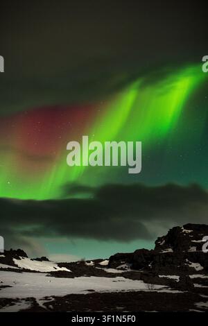 Aurora boreale (luci del nord) sulla paesaggio vulcanico e sul terreno ghiacciato e innevato del lago Mývatn, in Islanda. Foto Stock