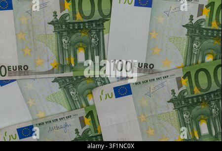 Una vista dettagliata dall'alto di diverse banconote da 100 euro verdi che si sovrappongono nel quadro. Foto Stock