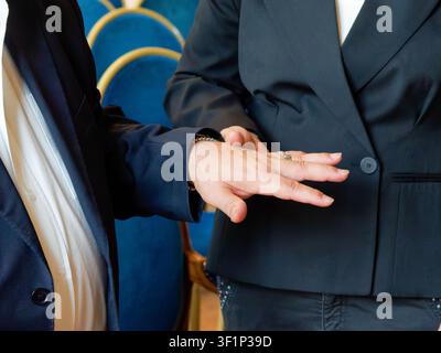 Donna che mostra l'anello nuziale sulla mano durante una cerimonia di matrimonio civile Foto Stock