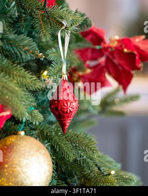 Decorazioni natalizie rosse e palline color oro sull'albero di Natale. Concetto di Natale e festività. Foto Stock