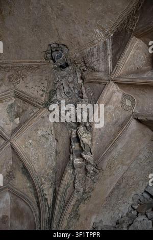Soffitto a volta danneggiato con intonaco crepato e muratura esposta nei monumenti storici Foto Stock