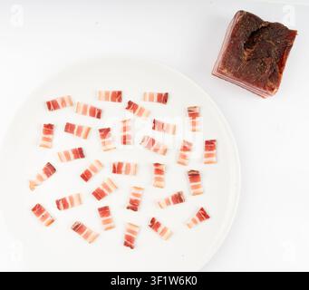 Carne di maiale carbonara cotta e tritata isolata, fette di pancetta affumicata cruda, fette di brisket striate, pancetta fresca affettata sottile su sfondo bianco Foto Stock