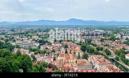 Vista ampia e elevata si affaccia sulla città di Lubiana, capitale della Slovenia, con i suoi caratteristici tetti in terracotta e le lontane colline ondulate. Foto Stock