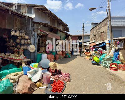 Un viaggiatore siede sotto un riparo della stazione su una piattaforma all'aperto della linea leggera a Addis Abeba. Foto Stock
