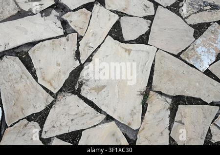 Prima orizzontale di una copertura del suolo in lastre di ardesia grigio chiaro consumate con terra nera tra i pezzi vari di ardesia Foto Stock