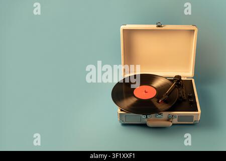 Un giradischi classico è aperto su uno sfondo blu solido, mostrando il suo fascino retrò e le sue capacità audio analogiche Foto Stock