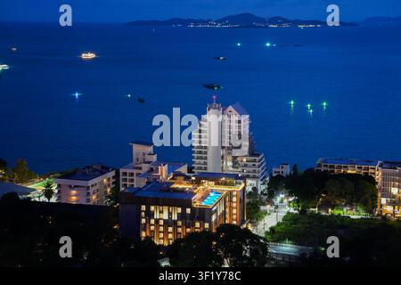 Pattaya Thailandia: Vista notturna elevata degli hotel costieri con piscina sul tetto e l'isola di Koh Larn all'ora blu Foto Stock