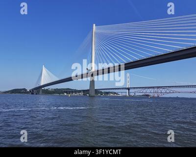 Vista estiva soleggiata del ponte stradale Queensferry Crossing che si estende sul Firth of Forth, catturata da una barca sull'acqua in Scozia. Foto Stock