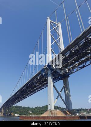 Progettazione sospesa storica del ponte stradale di Forth vista da una barca sul fiume Forth, Scozia. Vista in una giornata estiva soleggiata perfetta per immagini di viaggio. Foto Stock