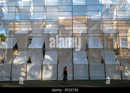 Tbilisi, Georgia. 15 luglio 2026. Una donna attraversa un edificio coperto da lenzuola protettive bianche a Tbilisi, Georgia il 15 luglio 2026. (Foto di Moe Zoyari/Sipa USA) Credit: Sipa USA/Alamy Live News Foto Stock