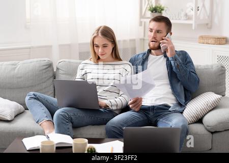 Partner sposati che lavorano da casa, comunicano con i clienti per telefono Foto Stock