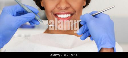 Bella femmina sorriso e mani dentista con strumenti Foto Stock