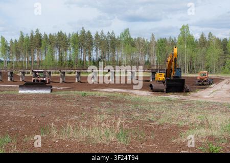 Macchine per l'estrazione della torba e attrezzature industriali su un paesaggio di brughiera raccolto Foto Stock