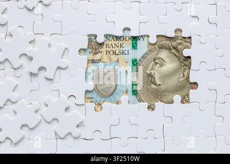 Moneta polacca. Banconota da 500 zloty tra pezzi di puzzle sparsi. Concetto aziendale. Analisi finanziaria. Tasso di cambio PLN. Tassi di interesse. Spazio di copia. B Foto Stock