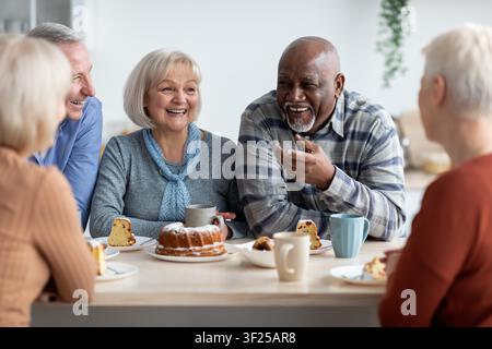 Coppia di anziani felici che godono di caffè e torta insieme a casa, concetto di perdita di peso Foto Stock
