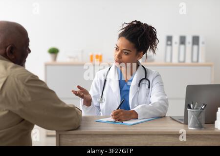 Dottoressa nera concentrata che consulta un paziente in clinica, concetto di assistenza sanitaria Foto Stock