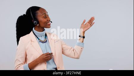 Auricolare, agente e donna nera con spazio in studio per consulenza call center su sfondo bianco. Persona felice, consulente o consigli pubblicitari con Foto Stock