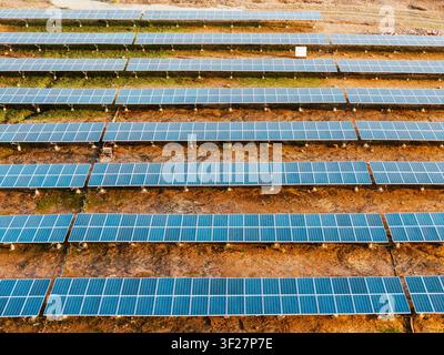 Vista a droni di una centrale solare fotovoltaica su vasta scala con migliaia di pannelli solari disposti in modelli geometrici. Foto Stock
