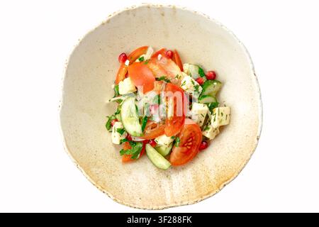 Insalata fresca di pomodori e cetrioli in una ciotola rustica Foto Stock