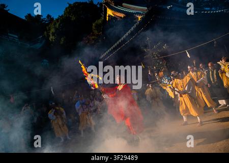 Il sommo sacerdote compie una preghiera durante la cerimonia della camminata sul fuoco al tempio Daisho-in sull'isola di Miyajima, in Giappone. Foto Stock
