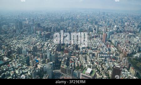 Veduta aerea ampia dello skyline di Taipei dall'osservatorio del Taipei 101 che mostra edifici urbani fittamente ammassati che si estendono fino all'orizzonte nebbioso Foto Stock