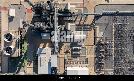 Vista aerea di una centrale elettrica a ciclo combinato con torretta di raffreddamento e sottostazione sotto un cielo azzurro, infrastruttura industriale di una centrale elettrica, scarico Foto Stock
