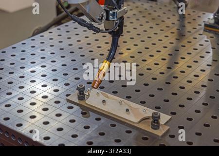 Piattaforma da tavolo per attrezzature di fabbricazione metallica saldata con braccio robotico Foto Stock
