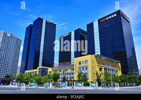 Un paesaggio urbano moderno che mostra diversi edifici di uffici ad alta altezza sotto un cielo blu limpido. Foto Stock