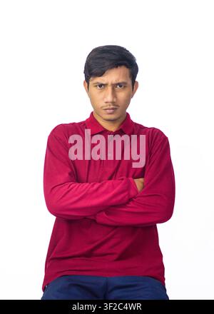 Ritratto di un giovane uomo asiatico sicuro di sé che indossa una camicia tradizionale indonesiana e posa su uno sfondo bianco da studio. Foto Stock