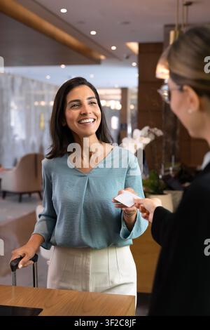 Ospite d'albergo che riceve la chiave magnetica alla reception Foto Stock