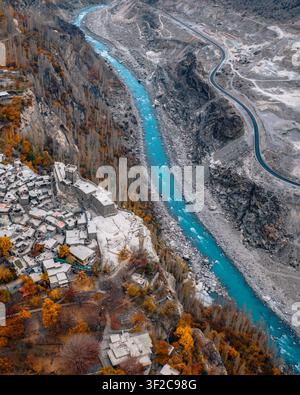 Veduta aerea del forte di Altit che si affaccia sul fiume Hunza turchese circondato da alberi autunnali e terreno montuoso impervio ad Altit, Hunza, Pakistan. Foto Stock