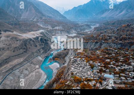 Veduta aerea del Forte di Altit che si affaccia sul fiume turchese di Hunza circondato da picchi montuosi frastagliati e fogliame autunnale nel villaggio di Altit, Hunza, Foto Stock