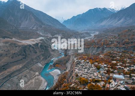 Vista aerea del Forte di Altit arroccato su una scogliera che si affaccia sul fiume Hunza turchese, circondato da alberi dai colori autunnali e da cime montuose impervie ad Al Foto Stock