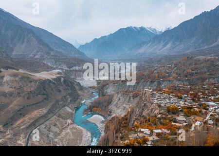 Vista aerea del forte di Altit situato su una scogliera rocciosa che si affaccia sul fiume Hunza, circondato da alberi dai colori autunnali e da cime montuose impervie ad Altit Foto Stock